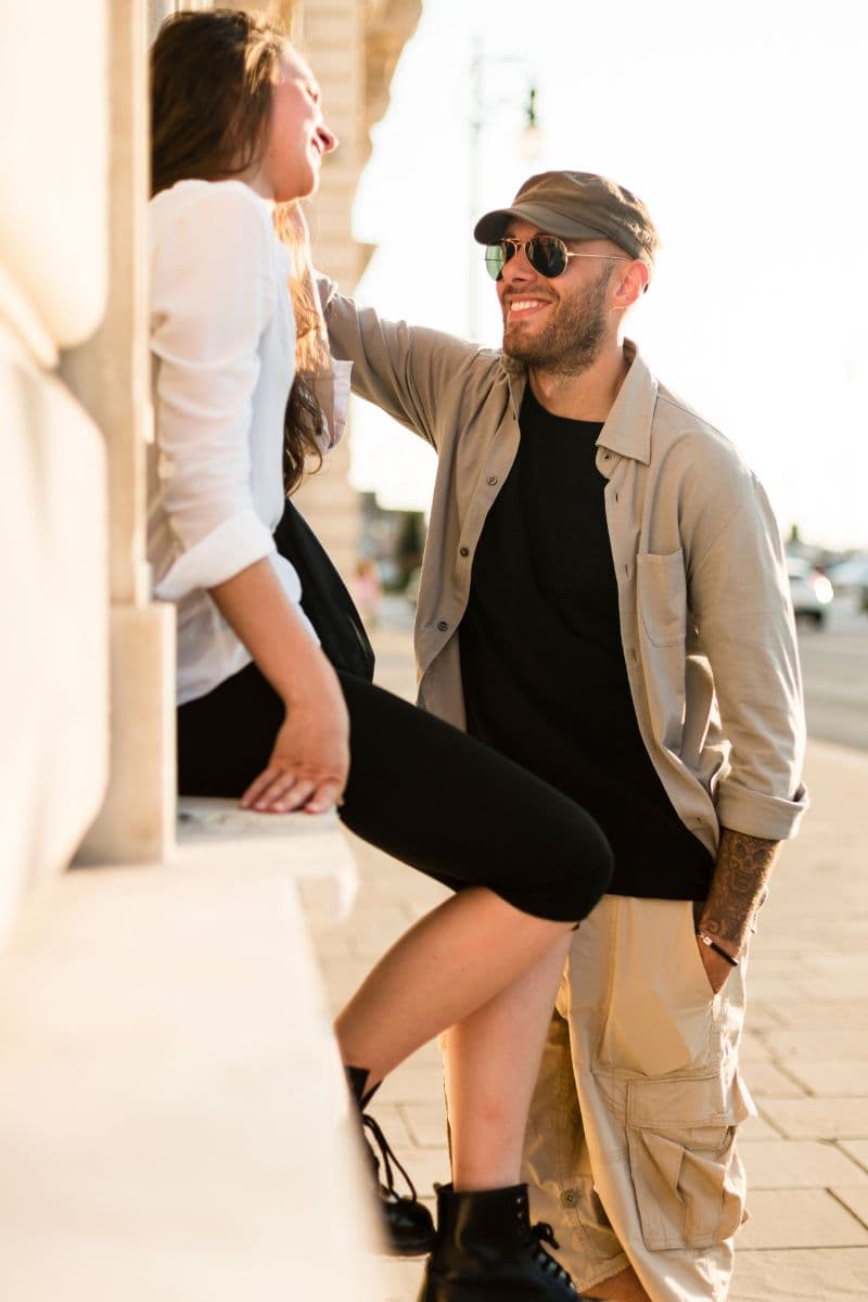 Couple flirting on a sidewalk.